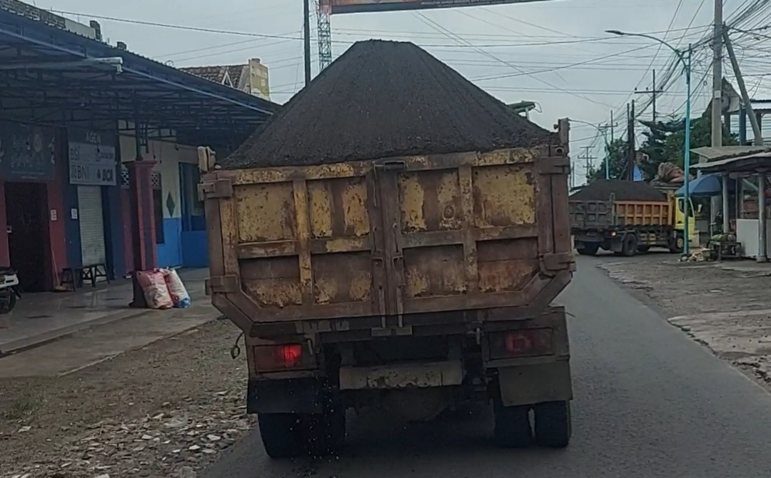 Beberapa truk material tanpa penutup terpal