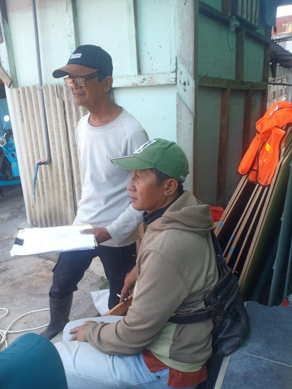 Haris dari konsultan pengawas berkaos putih sedang berdialog dengan mandor di proyek rumah pompa Sidokare I dan II