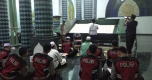 Disela-sela Bertugas Patroli, Polisi Banyuwangi Sempatkan Diri Baca Alquran Raksasa di Masjid Agung Baiturrahman