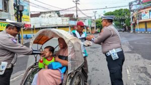 Jelang Nataru Polres Lumajang Beri Edukasi Masyarakat Tertib Lalu Lintas Sambil Berbagi Nasbung